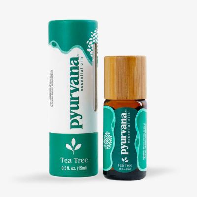 a bottle of the best tea tree oil for sale by Pyurvana next to a cardboard tube